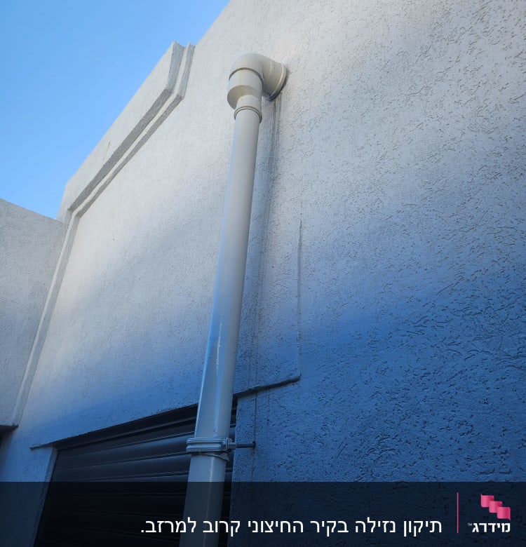 צינור ניקוז על קיר גג עם מרזב